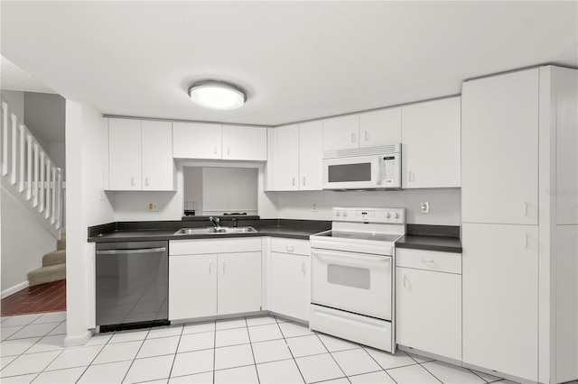 kitchen featuring sink, white appliances, white cabinets, and light tile patterned flooring