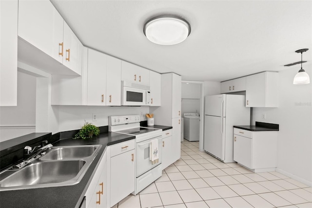 kitchen featuring white appliances, washer / dryer, dark countertops, white cabinetry, and pendant lighting