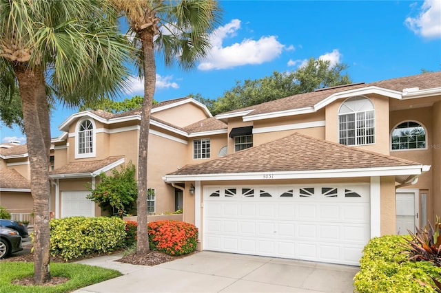 view of front of home with a garage, concrete driveway, a shingled roof, and stucco siding