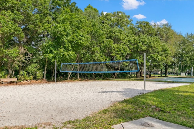 view of property's community with a lawn and volleyball court