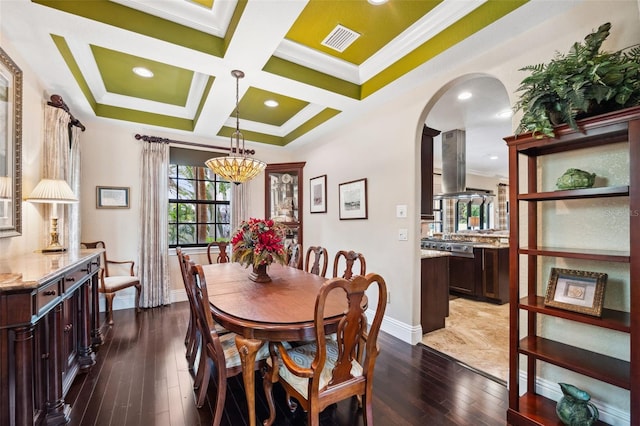 dining space featuring dark wood finished floors, visible vents, ornamental molding, arched walkways, and baseboards