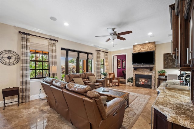 living room with recessed lighting, a fireplace, a ceiling fan, and ornamental molding