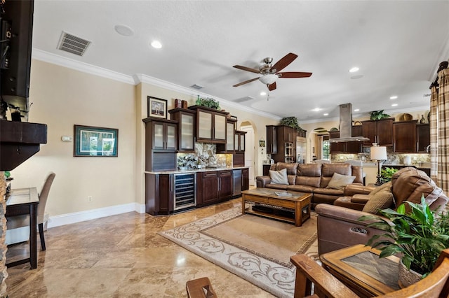 living room featuring wine cooler, arched walkways, visible vents, ceiling fan, and indoor wet bar