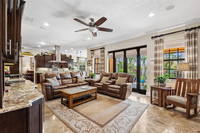 living area featuring a ceiling fan, arched walkways, crown molding, and recessed lighting