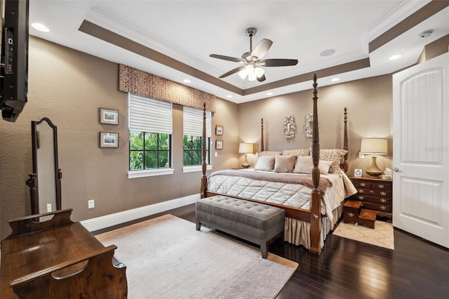 bedroom with wood-type flooring, baseboards, ornamental molding, and a raised ceiling
