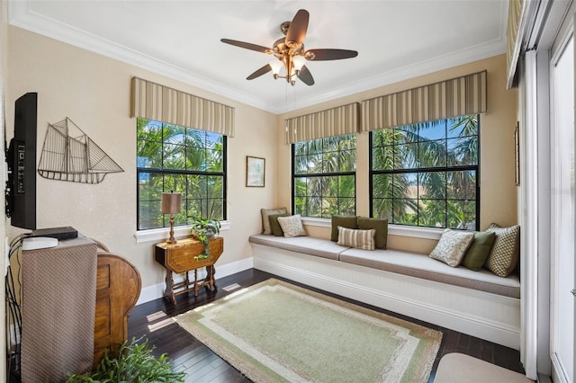 interior space featuring dark wood finished floors, a ceiling fan, baseboards, and ornamental molding