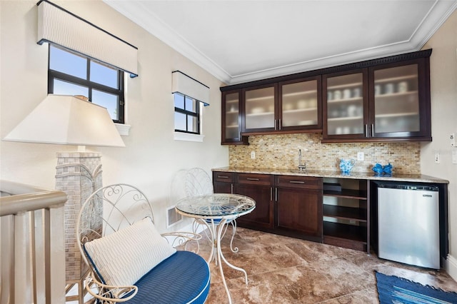 bar featuring wet bar, freestanding refrigerator, backsplash, and crown molding