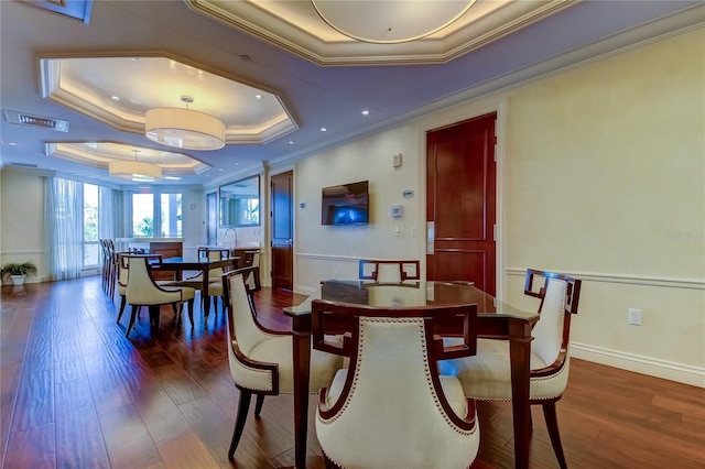 dining space with crown molding, sink, dark hardwood / wood-style flooring, and a tray ceiling