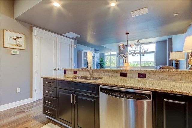 kitchen featuring sink, a chandelier, light wood-type flooring, dishwasher, and light stone countertops