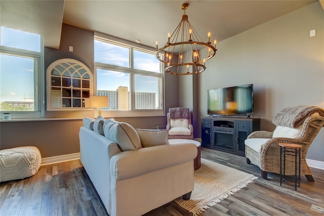 living room with a fireplace, wood-type flooring, and a chandelier