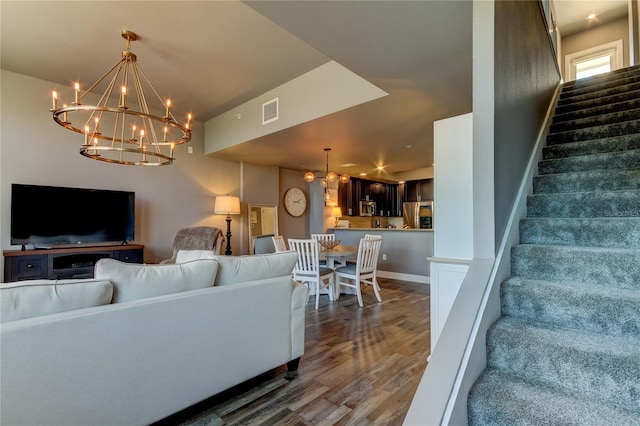 living room featuring dark wood-type flooring and an inviting chandelier