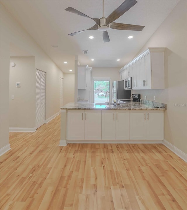 kitchen featuring white cabinets, light hardwood / wood-style flooring, kitchen peninsula, and ceiling fan