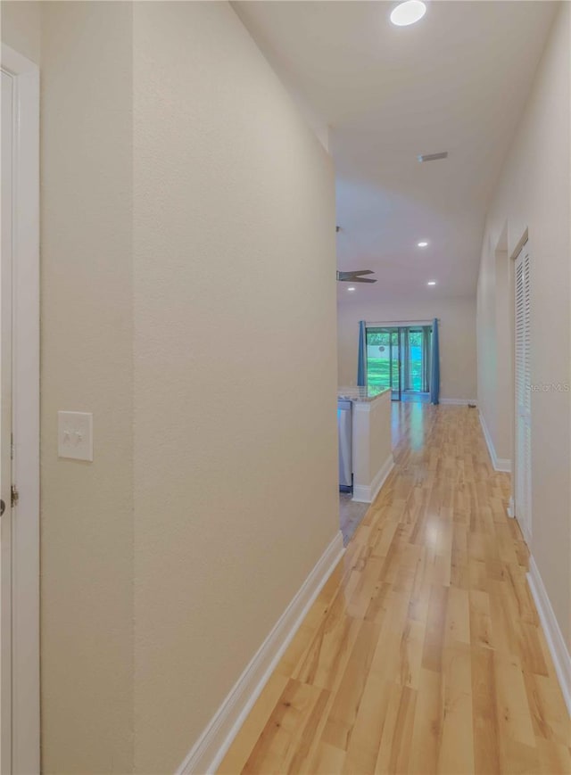 hallway with light hardwood / wood-style floors