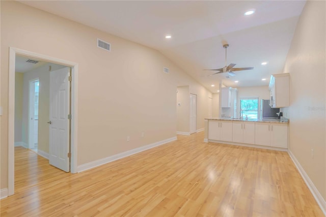 unfurnished living room featuring light wood-type flooring, vaulted ceiling, and ceiling fan