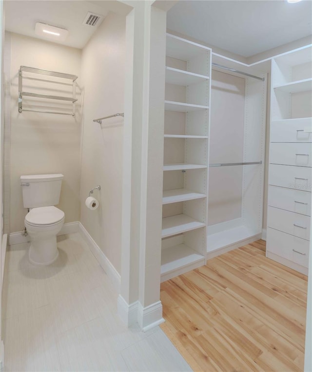 bathroom with toilet and hardwood / wood-style floors