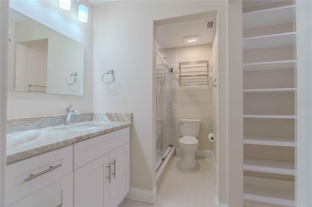 bathroom with an enclosed shower, vanity, toilet, and tile floors