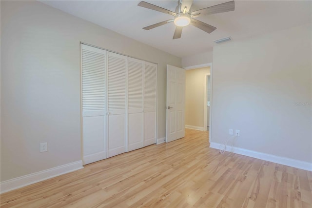 unfurnished bedroom with a closet, light wood-type flooring, and ceiling fan