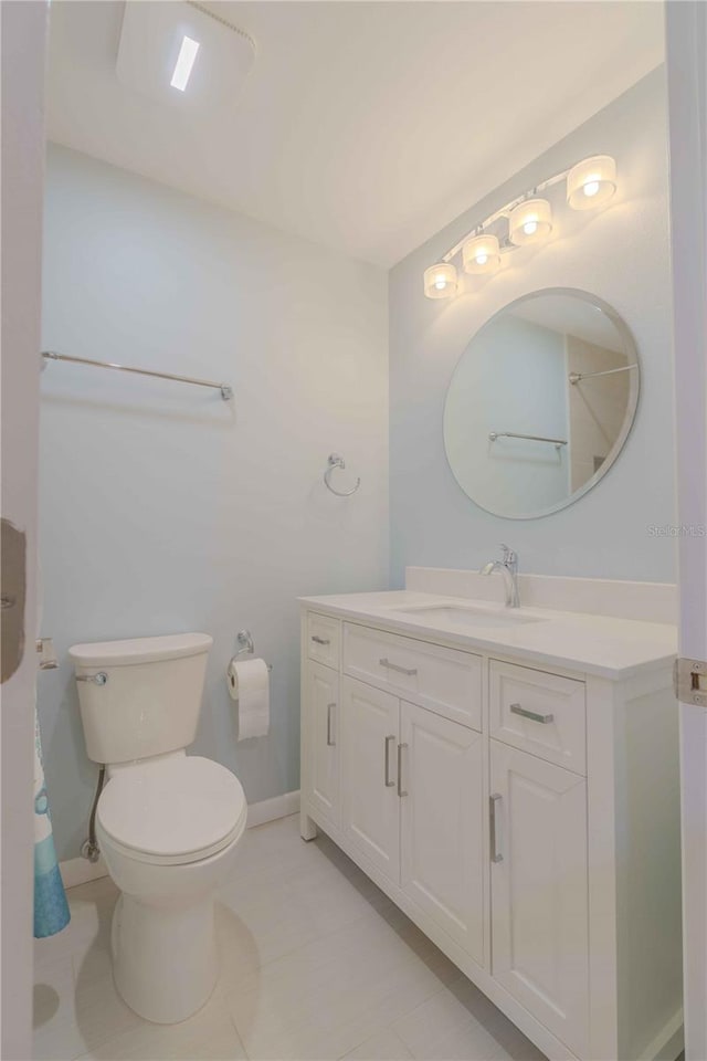 bathroom with tile floors, large vanity, and toilet