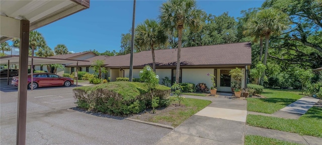 view of front of home with a carport and a front lawn