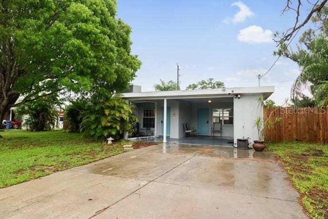 view of front of property with a front yard and a carport