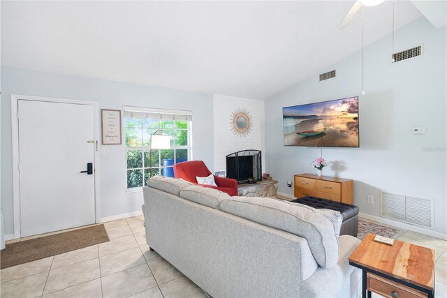 living room with ceiling fan, a fireplace, light tile patterned flooring, and lofted ceiling