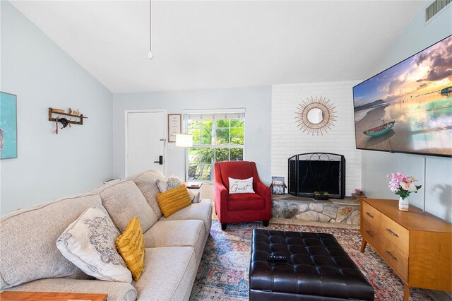 living room featuring a large fireplace and lofted ceiling