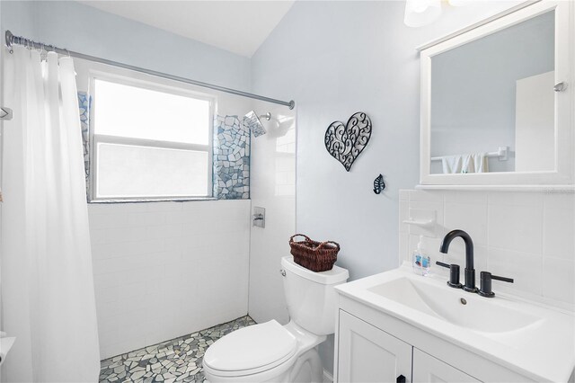 bathroom featuring backsplash, curtained shower, vanity, and toilet