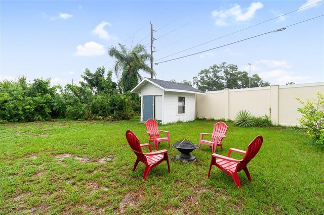 view of yard with a fire pit and an outdoor structure