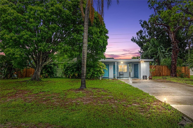 single story home featuring a lawn and covered porch