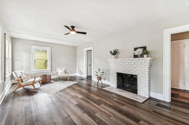 unfurnished room featuring a fireplace, a textured ceiling, dark hardwood / wood-style floors, and ceiling fan