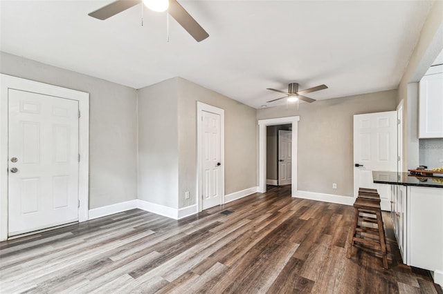 interior space with ceiling fan and dark hardwood / wood-style flooring