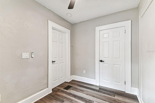 interior space with ceiling fan, dark hardwood / wood-style floors, and a textured ceiling