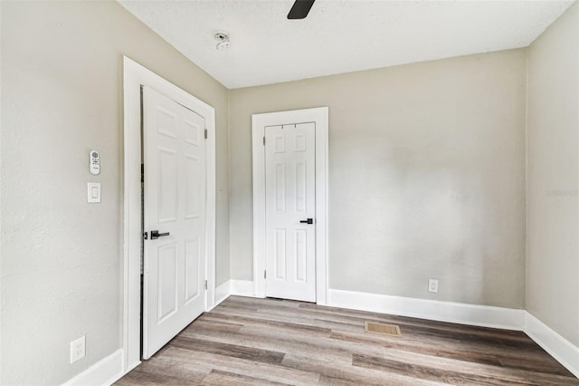 spare room with ceiling fan and wood-type flooring