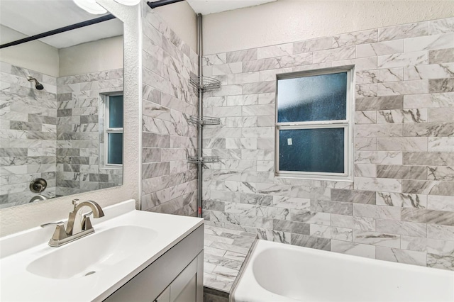 bathroom featuring vanity and tiled shower / bath