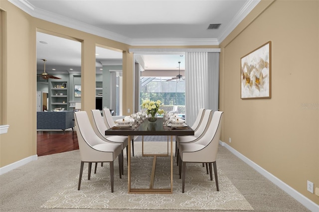 carpeted dining room featuring ornamental molding