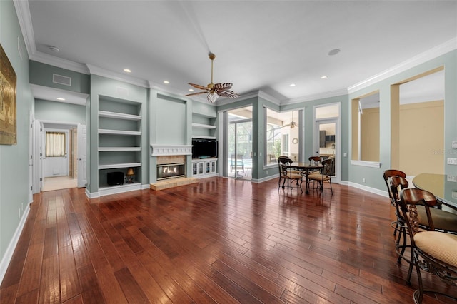 unfurnished living room featuring ceiling fan, hardwood / wood-style floors, built in features, and crown molding