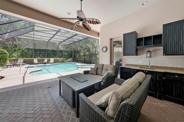 view of pool featuring an outdoor hangout area, a patio area, glass enclosure, and sink