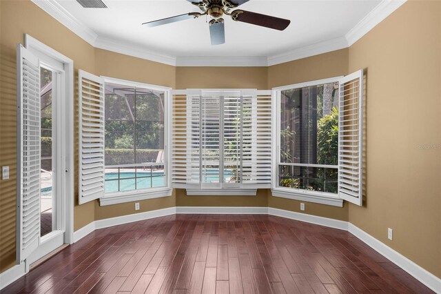 spare room featuring ornamental molding, dark wood-type flooring, and ceiling fan