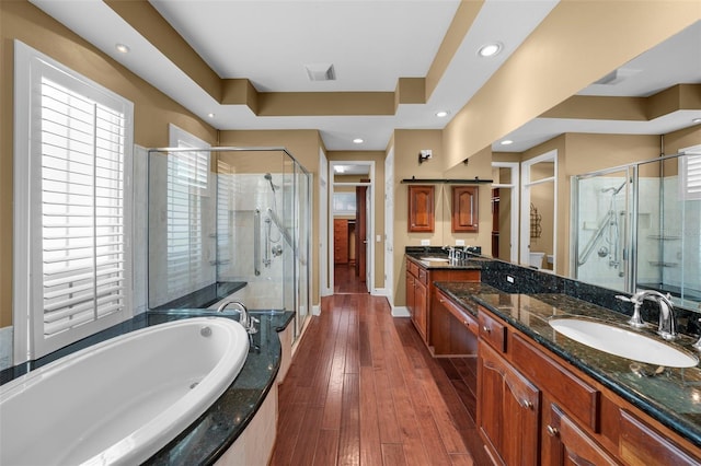 full bathroom with toilet, hardwood / wood-style floors, a tray ceiling, plus walk in shower, and vanity