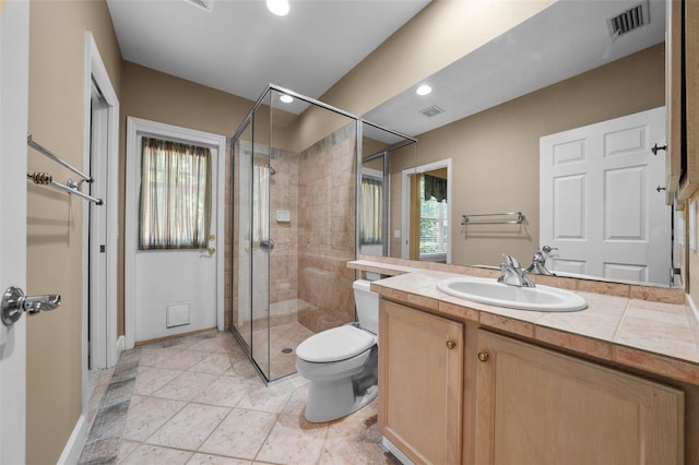 bathroom featuring toilet, walk in shower, vanity, and a healthy amount of sunlight