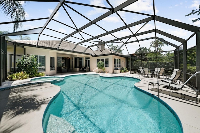 view of pool featuring a patio area, an in ground hot tub, and glass enclosure