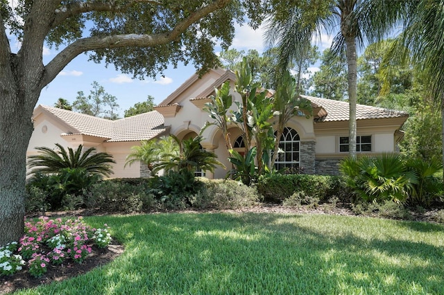 mediterranean / spanish home with a front yard