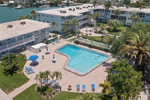 view of swimming pool with a water view and a patio