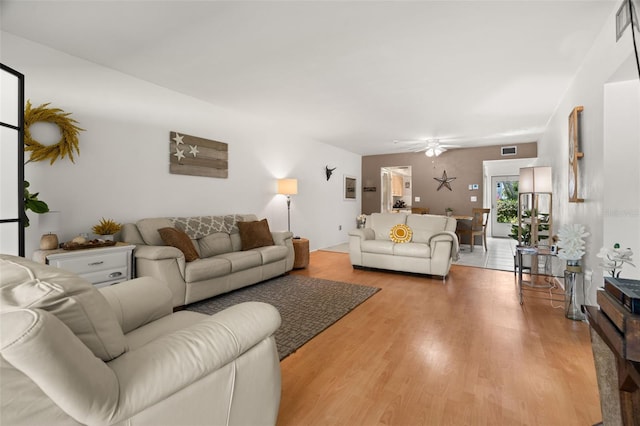 living room featuring ceiling fan and light hardwood / wood-style floors