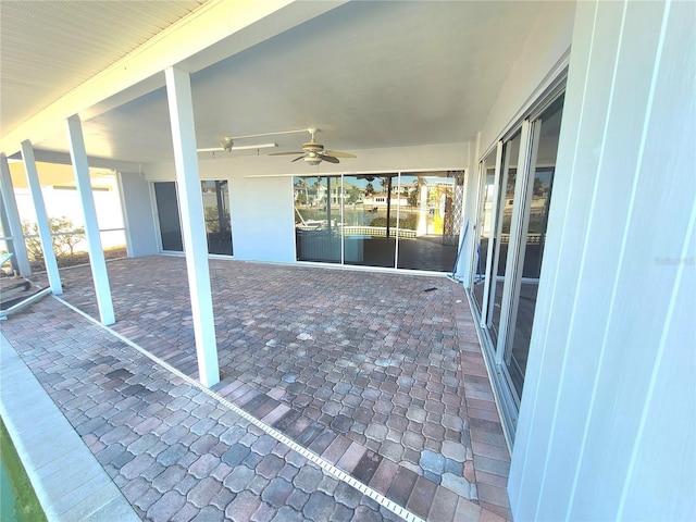 view of patio / terrace featuring ceiling fan and a water view