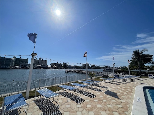 view of dock with a water view and a patio area