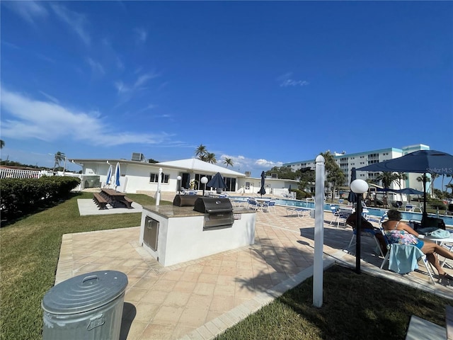 view of patio with area for grilling and a community pool