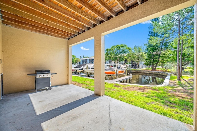 view of patio / terrace with area for grilling, a boat dock, and a water view