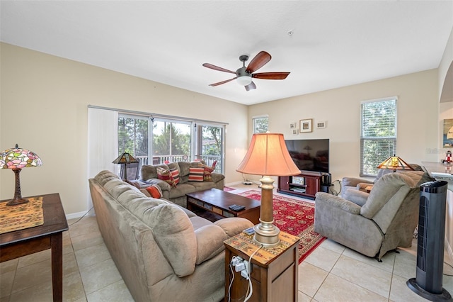 living room featuring ceiling fan, baseboards, and light tile patterned floors