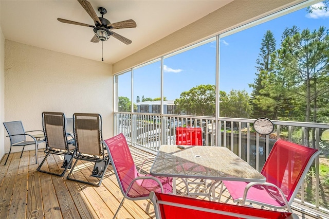 sunroom / solarium featuring a water view and ceiling fan